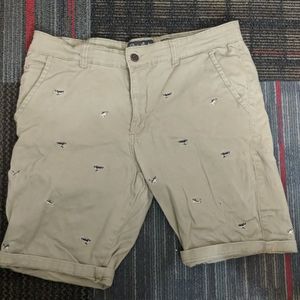 Chino shorts with embroidered shark pattern
